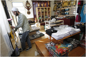 CSUEB student Jabir Tarin organizes inventory at his new store, Maqbool Islamic Clothing. (By: Bay Area News Group)